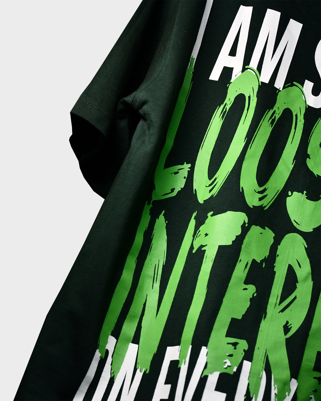 Close-up of TWYN Midori Ascend green oversized t-shirt with bold neon green back print reading ‘I am slowly losing interest on everything