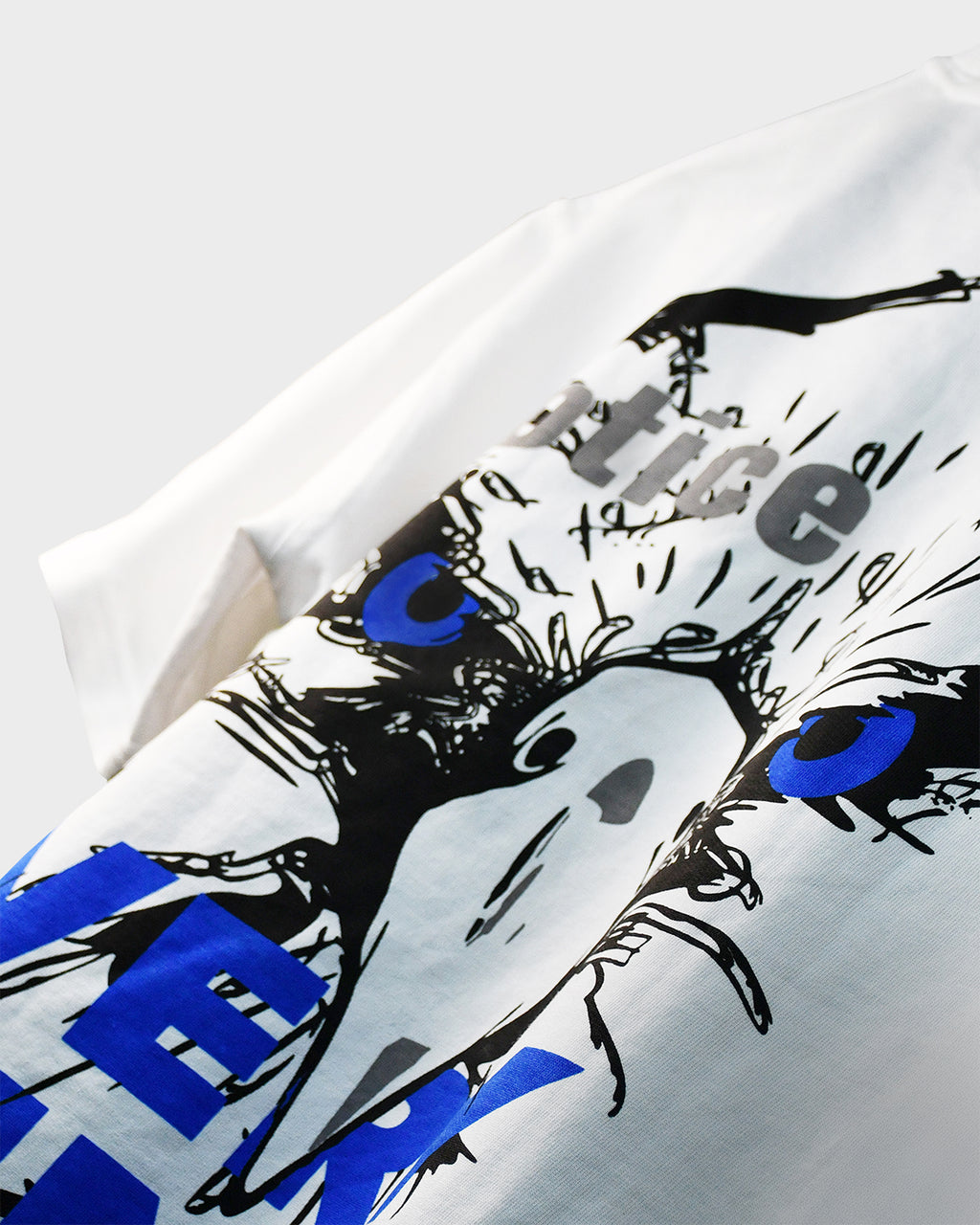 Close-up of black ‘Notice’ graphic print on TWYN white oversized t-shirt